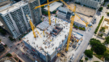 An Image Of A Dense Urban Construction Site With Several Cranes Visible.