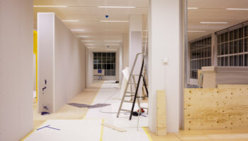 Image Of A Hallway With Offices On Both Sides, Currently In The Midst Of Renovation.