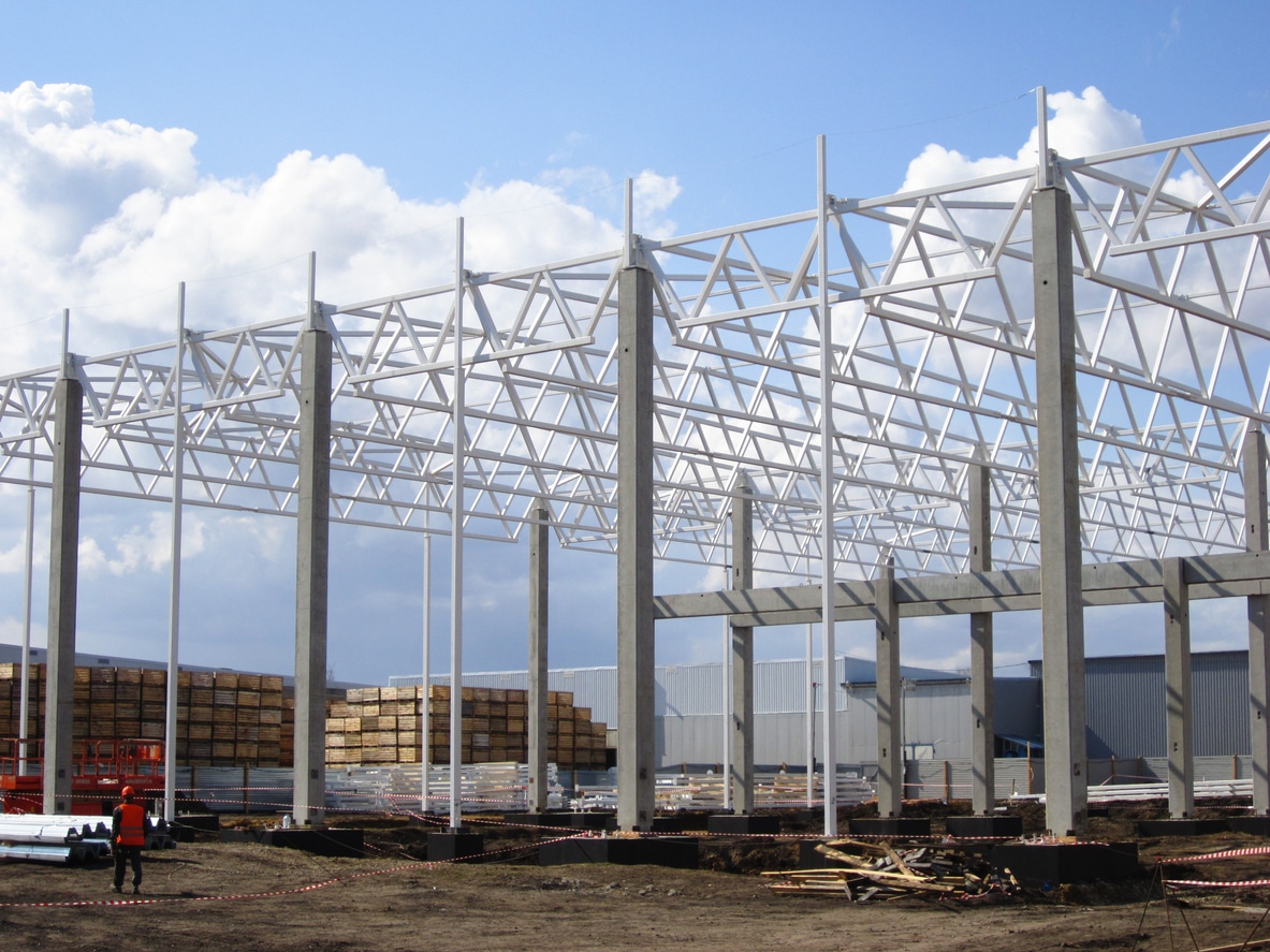 A large pre-engineered metal building being constructed.